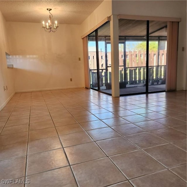 unfurnished room featuring baseboards, a textured ceiling, a chandelier, and tile patterned flooring