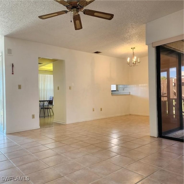 spare room with light tile patterned floors, visible vents, a textured ceiling, and ceiling fan with notable chandelier