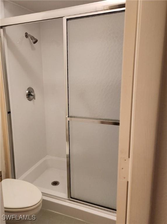 bathroom featuring a shower stall and toilet