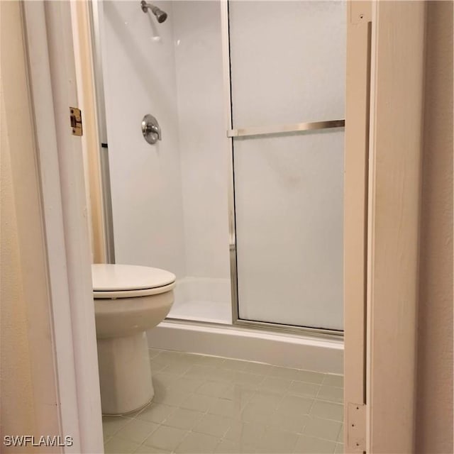 full bathroom with a stall shower and toilet