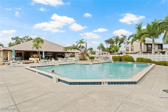 community pool featuring fence and a patio area