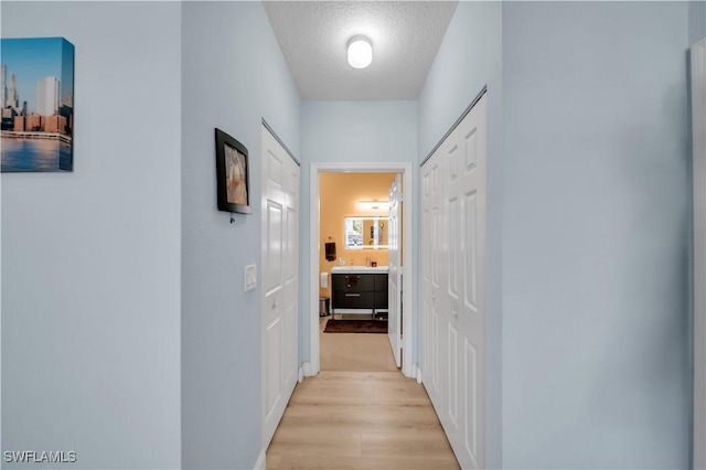 11510 Villa Grand Unit 408, Fort Myers, FL 33913 - corridor featuring a textured ceiling and light wood finished floors