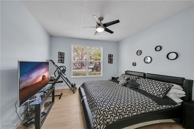 11510 Villa Grand Unit 408, Fort Myers, FL 33913 - bedroom featuring baseboards, a textured ceiling, wood finished floors, and ceiling fan