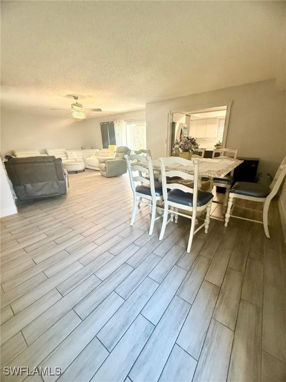 dining space featuring wood tiled floor and a textured ceiling