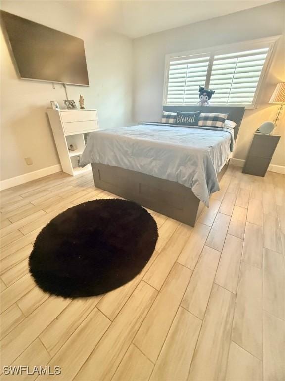 bedroom featuring baseboards and wood finished floors