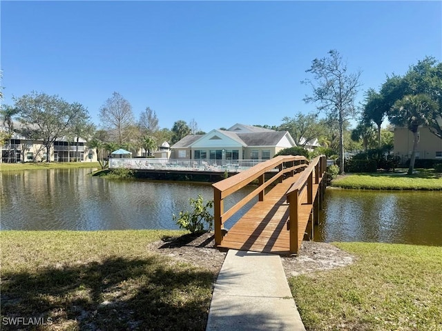 view of dock featuring a lawn and a water view