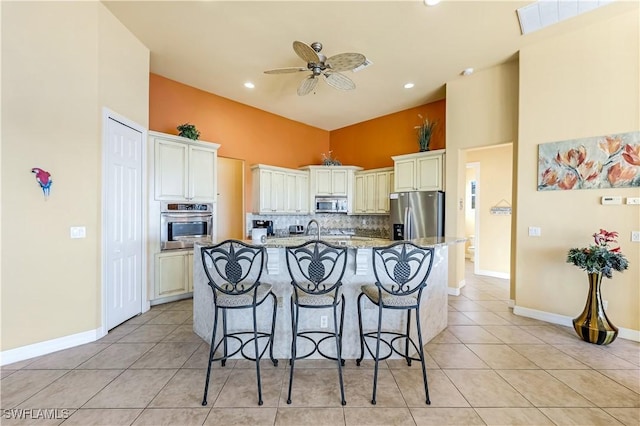 416 SW 52nd St, Cape Coral, FL 33914 - kitchen featuring light stone countertops, light tile patterned floors, a kitchen breakfast bar, appliances with stainless steel finishes, and a ceiling fan