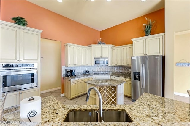 416 SW 52nd St, Cape Coral, FL 33914 - kitchen featuring a sink, appliances with stainless steel finishes, decorative backsplash, light stone countertops, and vaulted ceiling