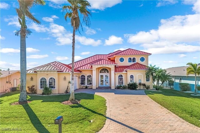 416 SW 52nd St, Cape Coral, FL 33914 - mediterranean / spanish home featuring french doors, decorative driveway, metal roof, and stucco siding