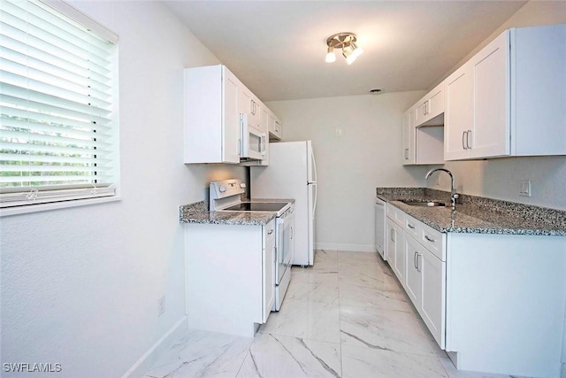 kitchen featuring white appliances, baseboards, dark stone counters, a sink, and marble finish floor