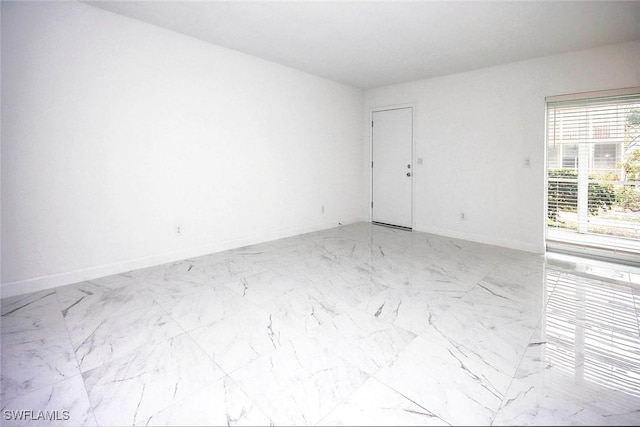 empty room with baseboards and marble finish floor