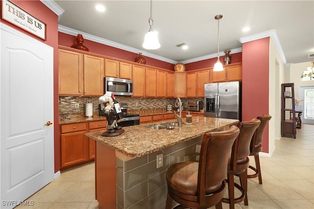 kitchen featuring ornamental molding, a sink, light stone counters, appliances with stainless steel finishes, and decorative backsplash