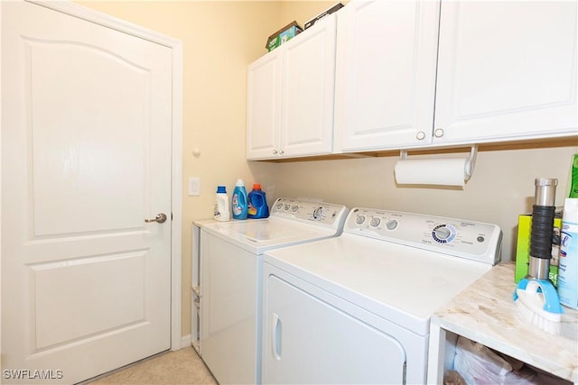 washroom featuring washing machine and clothes dryer and cabinet space