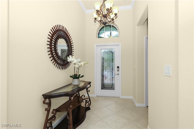 foyer entrance with a notable chandelier, baseboards, light tile patterned floors, and ornamental molding