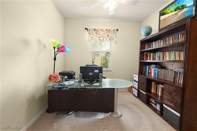 office featuring baseboards, light colored carpet, and a ceiling fan