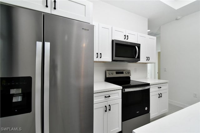 kitchen with white cabinets, appliances with stainless steel finishes, light countertops, and baseboards