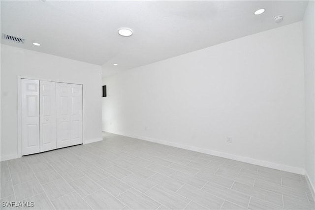 unfurnished bedroom featuring recessed lighting, baseboards, visible vents, and a closet