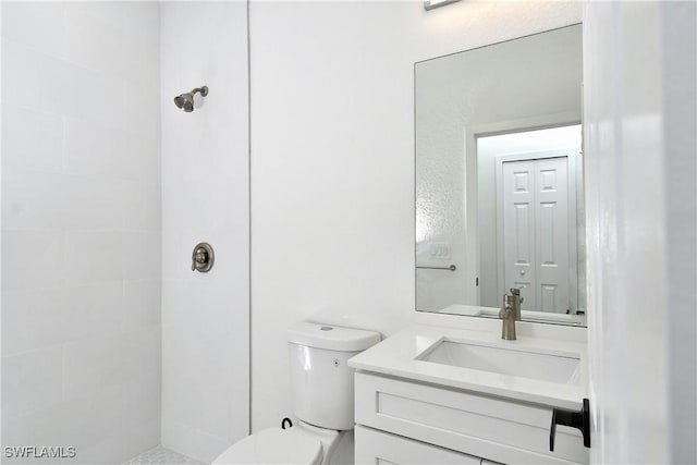 full bath with tiled shower, toilet, and vanity