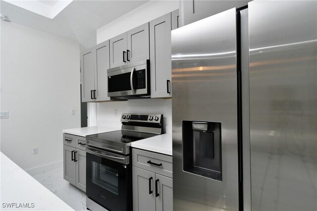 3204 69th St W, Lehigh Acres, FL 33971 - kitchen with light countertops, gray cabinets, stainless steel appliances, baseboards, and marble finish floor