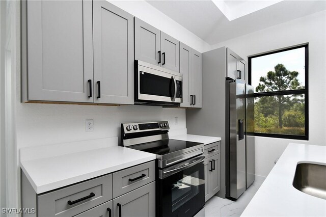 3204 69th St W, Lehigh Acres, FL 33971 - kitchen with light countertops, marble finish floor, appliances with stainless steel finishes, and gray cabinetry