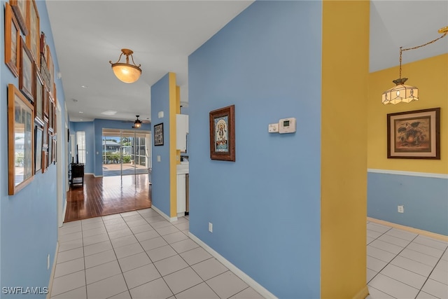 hallway featuring light tile patterned flooring and baseboards