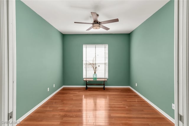 spare room with baseboards, a ceiling fan, and wood finished floors