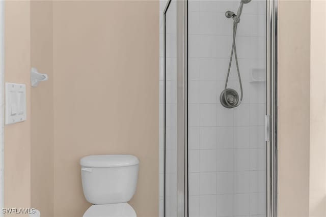 bathroom with a shower stall and toilet