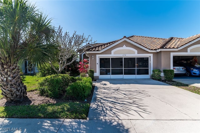 view of front facade featuring stucco siding, driveway, and a tile roof