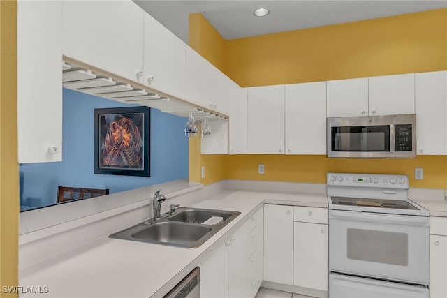 kitchen with a sink, stainless steel microwave, light countertops, and white range with electric stovetop