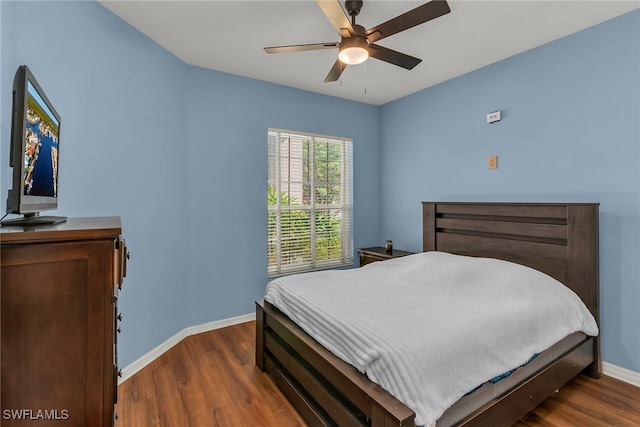 bedroom with baseboards, wood finished floors, and a ceiling fan