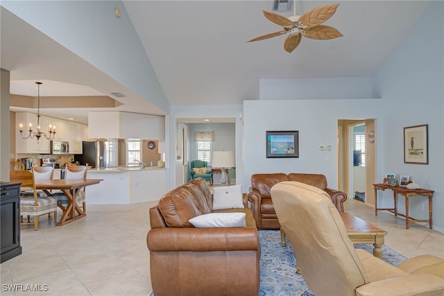 living room featuring light tile patterned flooring, ceiling fan with notable chandelier, visible vents, and high vaulted ceiling