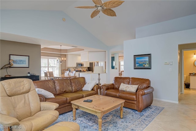 living area featuring light tile patterned flooring, ceiling fan with notable chandelier, high vaulted ceiling, and baseboards