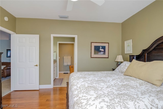 bedroom with a ceiling fan, baseboards, visible vents, light wood finished floors, and ensuite bathroom