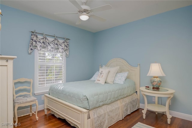 bedroom with a ceiling fan, wood finished floors, and baseboards