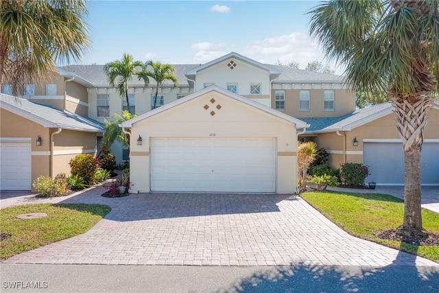 view of front of property featuring decorative driveway, a garage, and stucco siding