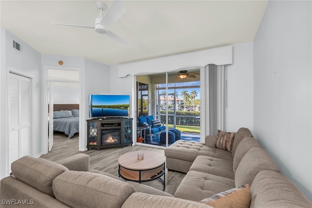 living area featuring visible vents, wood finished floors, and a ceiling fan