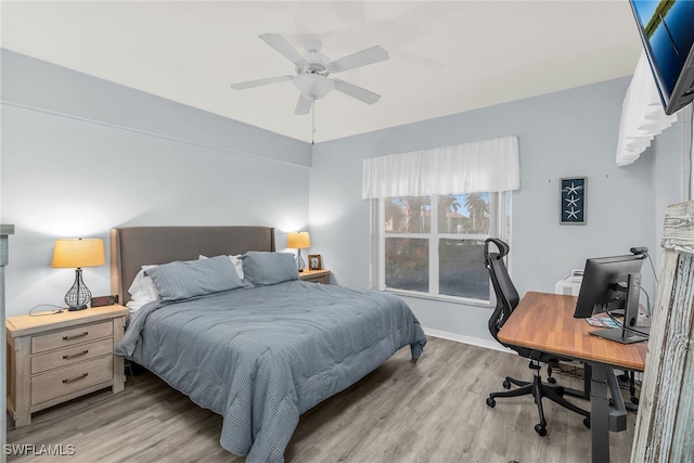 bedroom featuring a ceiling fan, wood finished floors, and baseboards