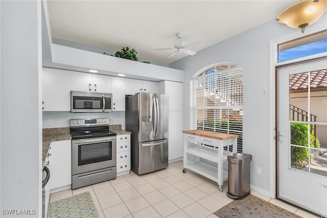 kitchen featuring white cabinets, light tile patterned floors, appliances with stainless steel finishes, and ceiling fan