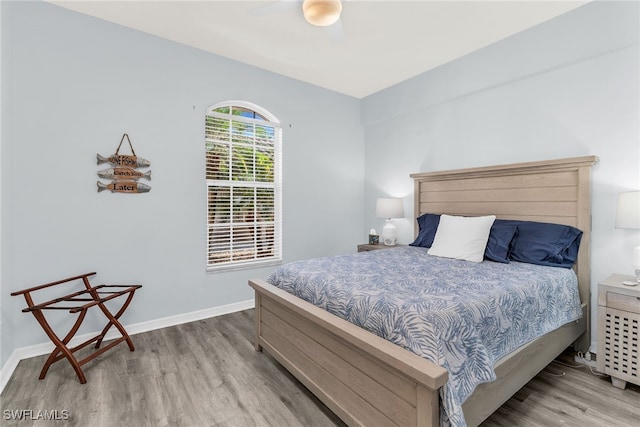 bedroom with wood finished floors, baseboards, and ceiling fan