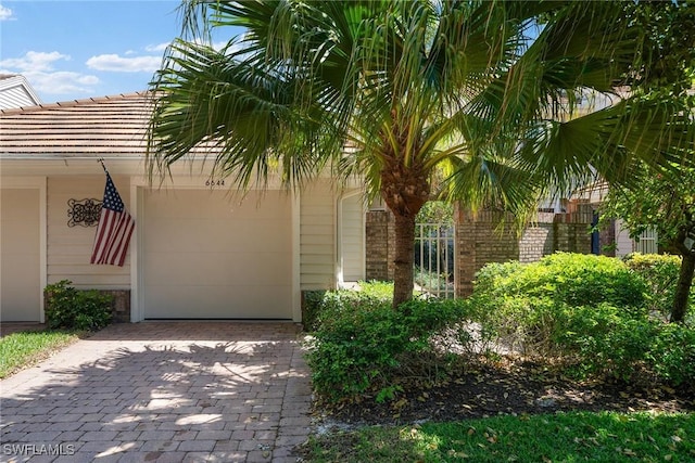 view of front of property featuring decorative driveway and an attached garage