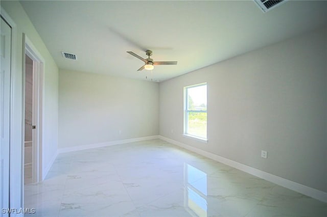 spare room featuring visible vents, marble finish floor, and baseboards