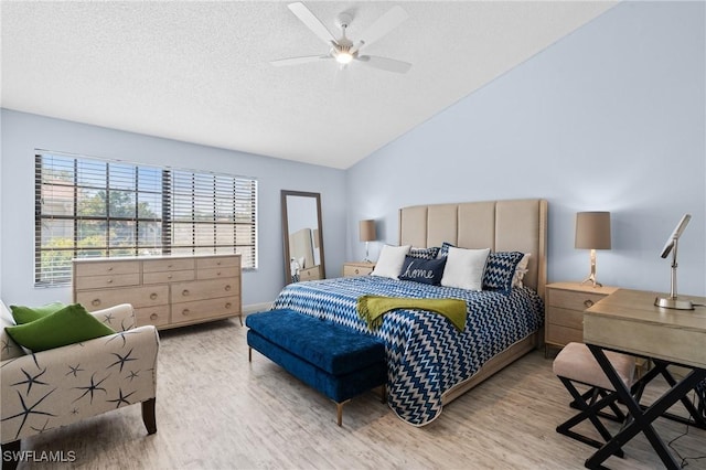 bedroom with ceiling fan, vaulted ceiling, wood finished floors, and a textured ceiling