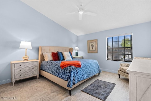 bedroom with ceiling fan, wood finished floors, baseboards, and vaulted ceiling