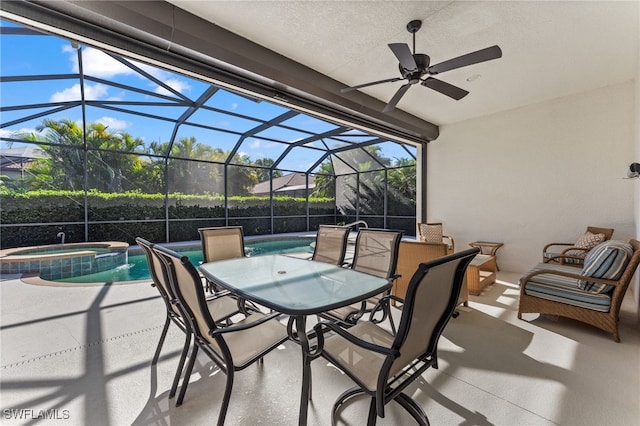 view of patio with glass enclosure, a pool with connected hot tub, and a ceiling fan