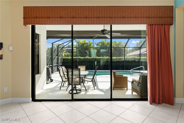 doorway featuring light tile patterned floors, plenty of natural light, a ceiling fan, and a sunroom
