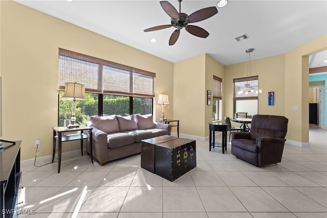 living room featuring light tile patterned floors, baseboards, visible vents, and ceiling fan