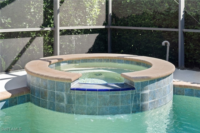 view of swimming pool with a lanai and a pool with connected hot tub