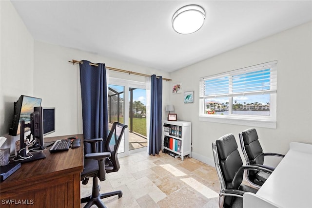 home office with stone finish flooring and baseboards