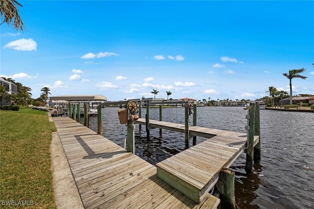 dock area with a yard, a water view, and boat lift