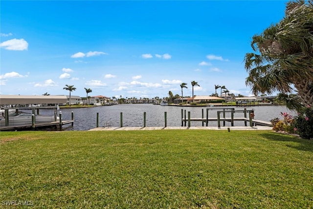 view of dock featuring a lawn, a water view, and boat lift